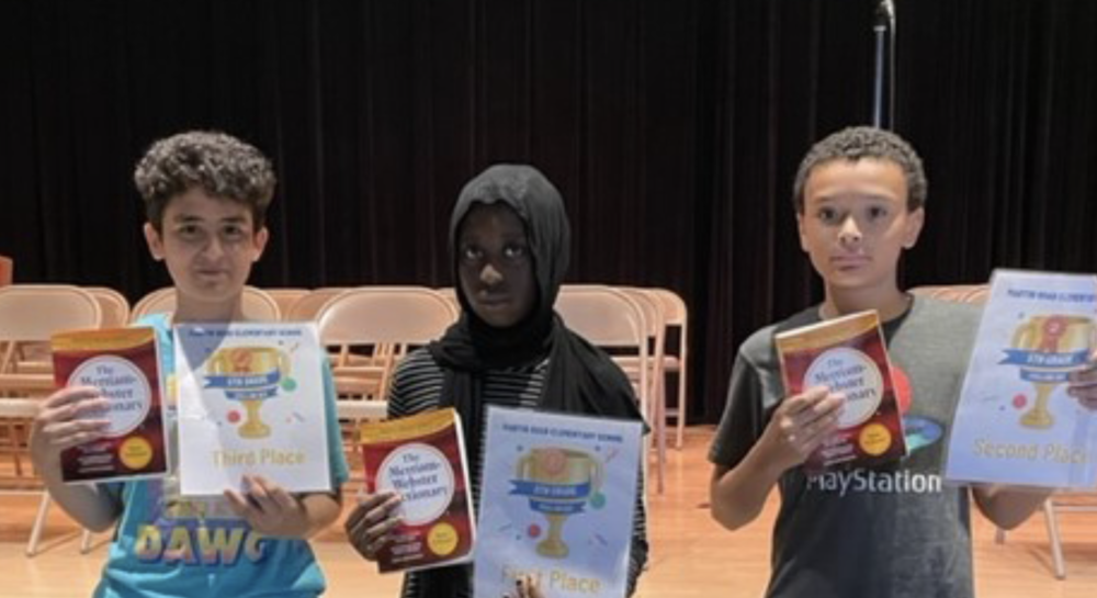 three young students holding up their awards