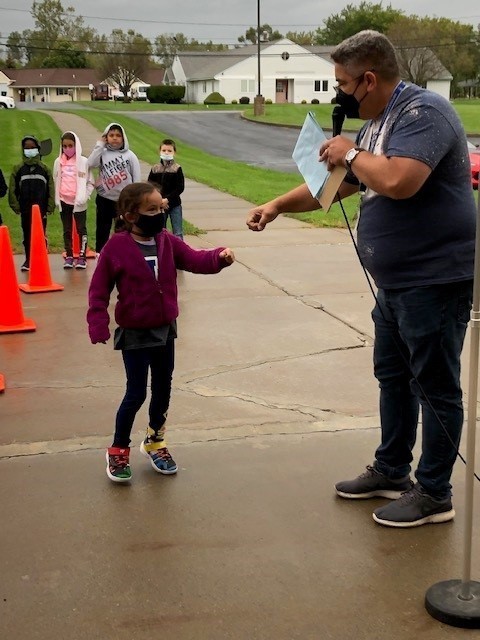 student giving a fist bump to an adult at the walkathon